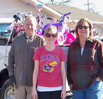 bikes loaded in back of truck with three people smiling